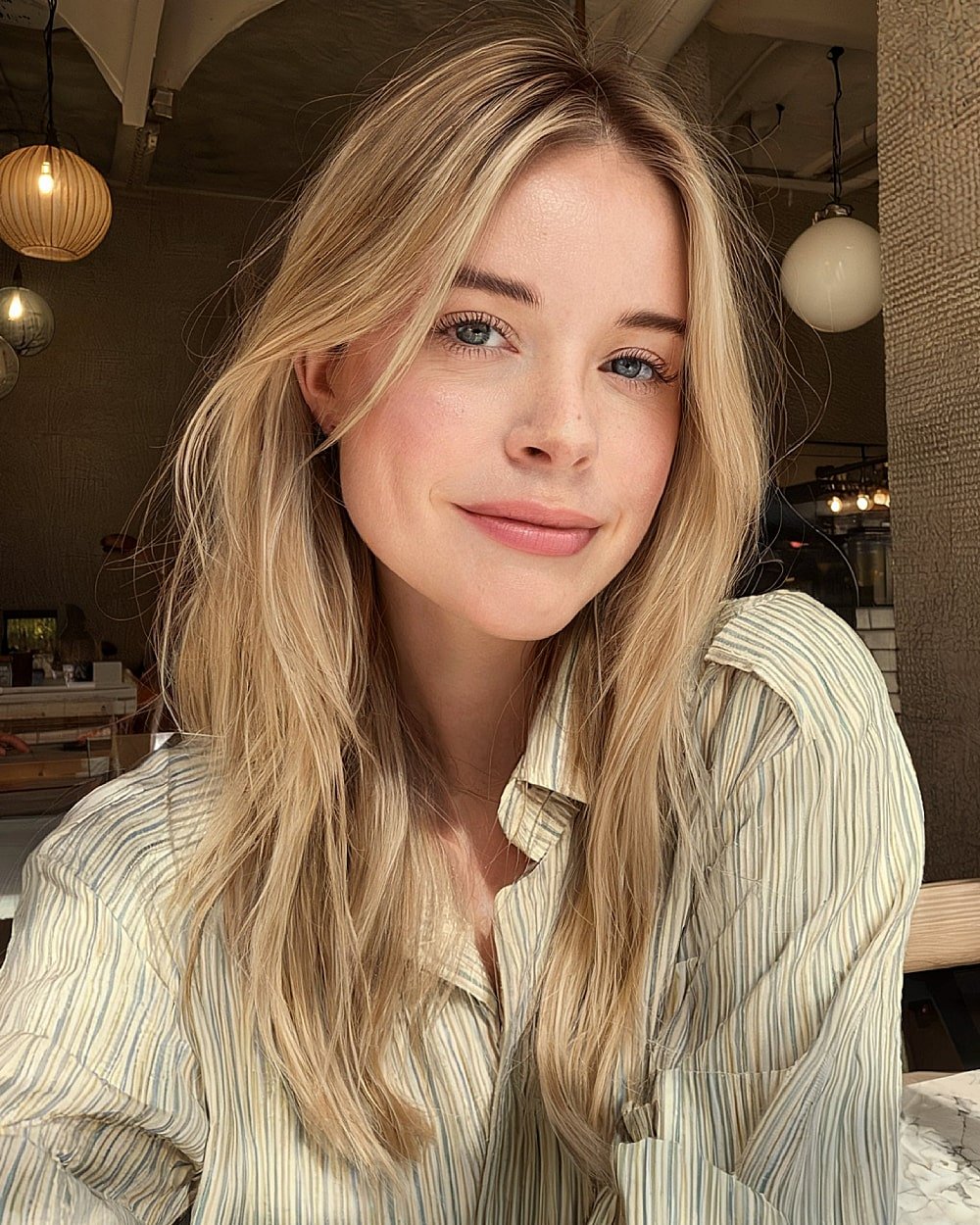 Flache, geschichtete blonde Haare mit einem mittleren Teil und langen Gesichtsschichten